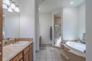 Bathroom with vanity, a stall shower, a garden tub, light tile patterned flooring, and recessed lighting
