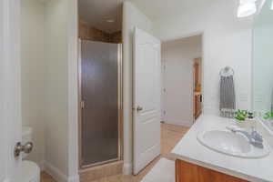 Bathroom with vanity, a stall shower, and light tile patterned flooring