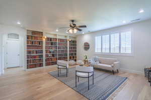 Living area featuring light wood-type flooring, a ceiling fan, and recessed lighting
