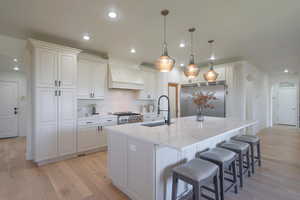 Kitchen featuring arched walkways, a breakfast bar, light stone countertops, backsplash, and pendant lighting