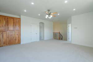Unfurnished room featuring recessed lighting, light colored carpet, arched walkways, and ceiling fan