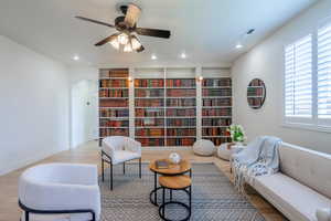 Living area with arched walkways, wood finished floors, recessed lighting, and a ceiling fan