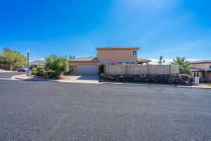 View of front of property with an attached garage, stucco siding, and concrete driveway