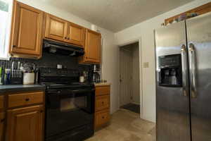 Kitchen with stainless steel refrigerator with ice dispenser, black electric range, tasteful backsplash, under cabinet range hood, and brown cabinetry