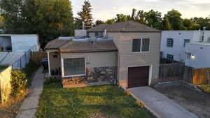 View of front facade featuring a fenced backyard, a garage, roof with shingles, and concrete driveway