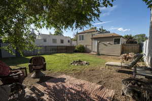 Fenced backyard with a fire pit and a patio area