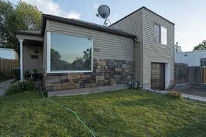 Back of house with stone siding and a garage