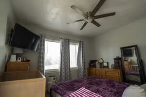 Bedroom with a textured ceiling and ceiling fan