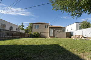 Rear view of house with a fenced backyard