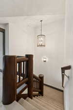 Staircase featuring carpet and a chandelier