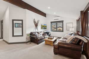 Living area featuring carpet floors, recessed lighting, and a wall mounted air conditioner