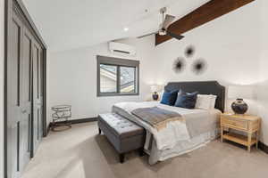 Bedroom featuring light colored carpet, ceiling fan, an AC wall unit, and a closet