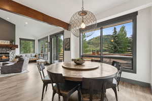 Dining space featuring a stone fireplace, light wood-style flooring, and recessed lighting
