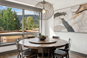 Dining area with a textured wall, wood finished floors, and a view of trees
