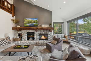 Living area featuring a fireplace, recessed lighting, wood finished floors, and high vaulted ceiling