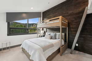 Bedroom featuring wooden walls and light carpet