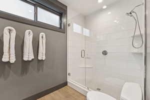 Bathroom featuring a stall shower, recessed lighting, and wood finished floors