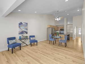 Sitting room with high vaulted ceiling, light wood finished floors, recessed lighting, and a ceiling fan