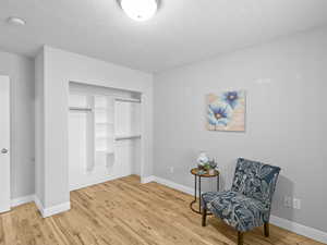 Sitting room featuring light wood finished floors and a textured ceiling
