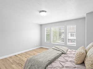 Bedroom featuring light wood-style flooring and a textured ceiling