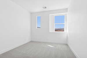 Spare room featuring light colored carpet and baseboards