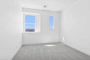 Unfurnished room with light carpet and baseboards