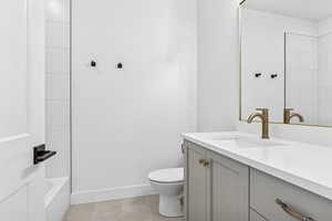 Bathroom featuring vanity, light tile patterned floors, and shower / washtub combination