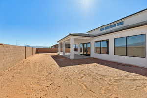 Rear view of house featuring a patio area, a fenced backyard, and stucco siding