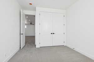 Unfurnished bedroom with light carpet, recessed lighting, and a closet