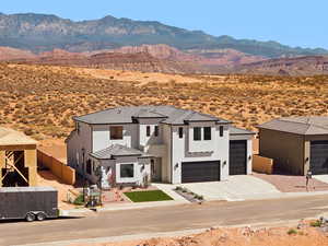 View of front of home featuring a mountain view, stucco siding, driveway, view of desert landscape, and a tiled roof