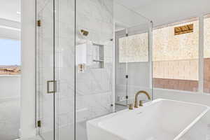 Bathroom featuring a soaking tub and a stall shower