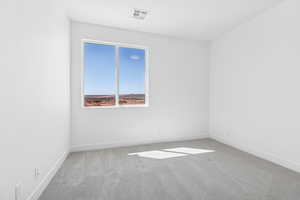 Carpeted spare room featuring baseboards