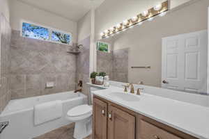 Full bath featuring shower / bath combination, vanity, and light tile patterned flooring