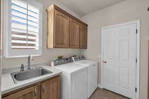Laundry area featuring cabinet space, independent washer and dryer, and light tile patterned flooring