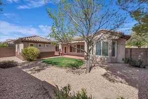 Back of house with stucco siding, a tiled roof, and a patio area
