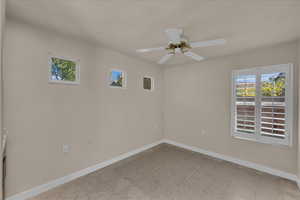 Empty room with baseboards and a ceiling fan