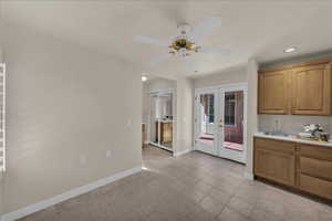 Kitchen with french doors, light countertops, brown cabinetry, a ceiling fan, and recessed lighting