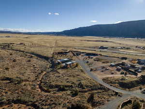 Aerial view of property and surrounding area featuring rural landscape and a mountainous background