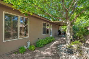 View of side of property featuring stucco siding and a patio area