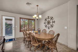 Dining space with a chandelier and lofted ceiling