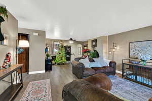 Living room with ceiling fan and light wood-style floors