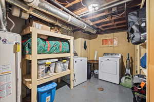 Unfinished below grade area featuring water heater and washer and dryer