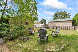 View of yard with an outdoor structure and a fire pit