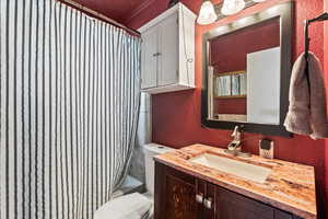 Full bath featuring a textured wall, shower / bath combination with curtain, and vanity