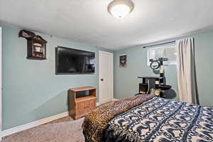 Bedroom with carpet floors and a textured ceiling