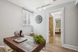 Office space featuring light wood-type flooring and rail lighting