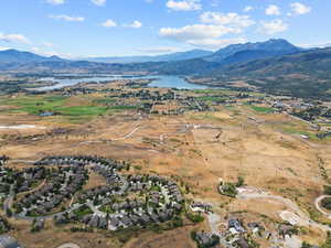 Aerial view of property's location with a water and mountain view and nearby suburban area