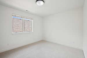 Unfurnished room with baseboards and light colored carpet