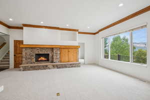 Unfurnished living room with carpet floors, a fireplace, ornamental molding, a mountain view, and recessed lighting