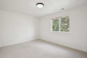 Empty room with light carpet and baseboards